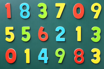 Colorful numbers on green background, flat lay