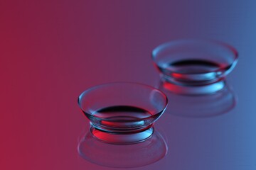 Pair of contact lenses on mirror surface, closeup