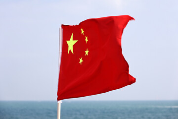 Flag of China on blue sky and sea background
