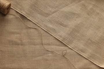 Spool of thread on burlap fabric, top view