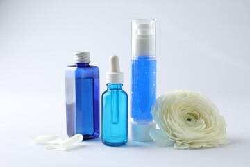 Set of luxury cosmetic products and gentle flower on white background