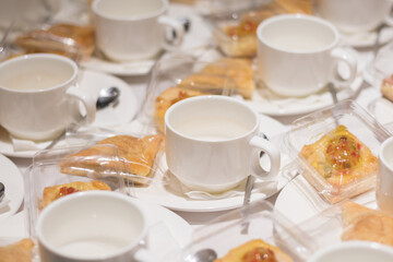 Coffee cups and croissants on a white tablecloth, Cup of coffee and croissant on white shabby chic background.