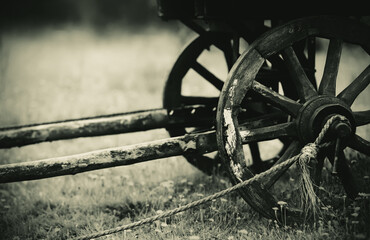 Monochrome photo of an old wooden cart with a sepia filter, which is typically pulled by horses,...