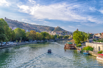 pleasure boat on the waves of the Kura River in Tbilisi Georgia © Sofiia