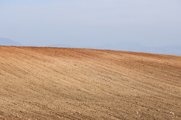 Fototapeta premium Agricultural field ploughed in spring. Arable land ready for the next cultivation season