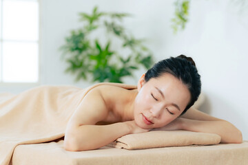 Obraz na płótnie Canvas マッサージベッドに寝る女性