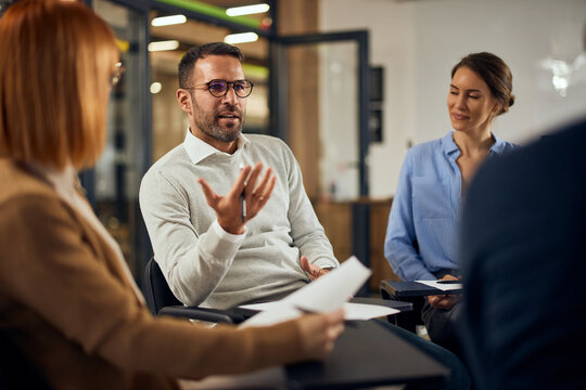 Group of business people having psychotherapy sessions at the workplace, talking to a therapist.