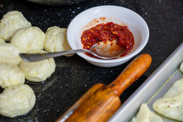 preparing arabic traditional pastries by female hands stuffing them with spinach and red chili