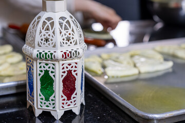 mother preparing food in kitchen during ramadan for her family , famous in front