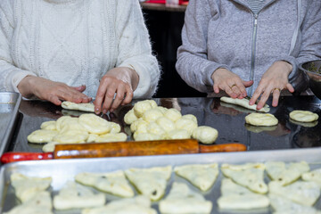 Obraz na płótnie Canvas preparing arabic traditional pastries by female hands stuffing them with spinach and red chili