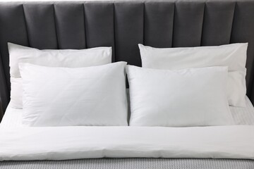 Soft white pillows and duvet on bed