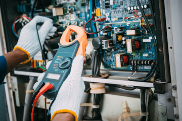 Technician is checking air conditioner refrigerant system maintenance and check switch board control