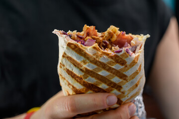 Kebab lawasz w tortilli z bliska, pyszny gorący posiłek w dloniach - obrazy, fototapety, plakaty