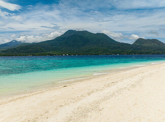 Fototapeta na wymiar Sandy beach with ocean waves. Transparent turquoise sea water. White Island. Camiguin, Philippines.