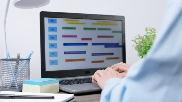 Concept of planning dates, time management. Schedule of meetings and events on the laptop screen. Business woman uses a calendar to organize events.