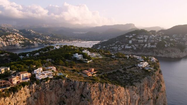 Breathtaking aerial drone view of Mallorca cliff with sea view property on the top. Idyllic vacation destination. Holiday rental in the island. Real estate development with vacation homes and resorts