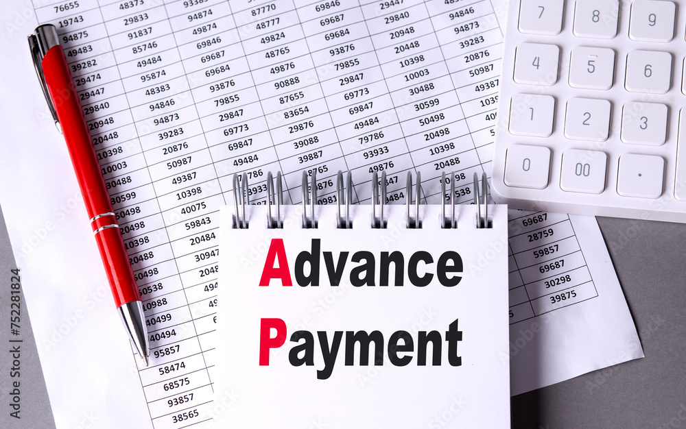 Aufkleber advance payment text on notebook with pen, calculator and chart on grey background