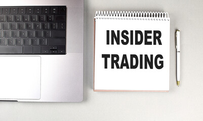 INSIDER TRADING text on notebook with laptop and pen