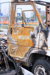 Particolare della  porta di un furgone bruciato, rottami bruciati