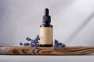 Obraz na płótnie Canvas Glass dropper bottle of Lavender essential oil with dried lavender flowers