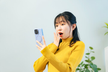 スマホを見て驚く女性