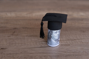 Closeup image of graduation cap and money on table. Scholarship, educational fees concept. Copy...