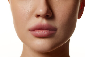 Cropped close-up image of beautiful female face, plump lips with nude lipsticks makeup isolated...