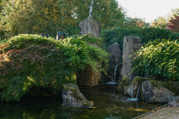 Scenic Japanese style gardens with a waterfall in the park of Bietigheim-Bissingen, Baden-Wuerttemberg, Germany, Europe. Japanese water garden. Waterfall with trees in Japanese green Garden Park green