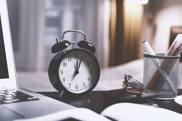 An office desk hosts a clock, a silent guardian of time in the bustling world of productivity.
