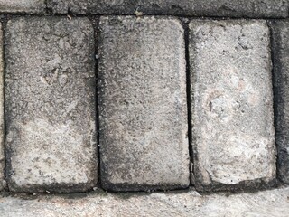 Close-up of a weathered red brick wall with peeling paint, revealing the aged texture and imperfections of the bricks.