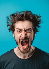 Portrait of a young man shouting on a blue background.