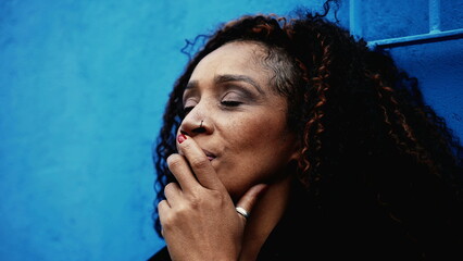 One pensive woman in 50s struggling with regrets and past mistakes, contemplative African American...