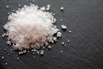 White salt cristals for food on the black background.