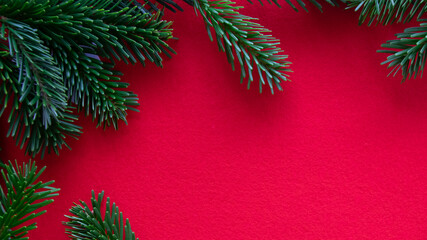 Winter red background with branch, needle of Christmas tree.