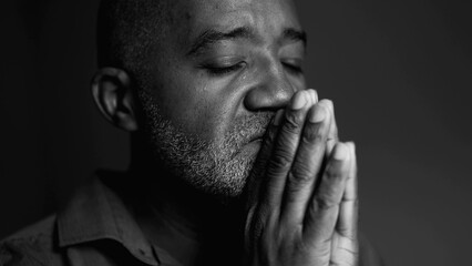 One Serious elderly black man in deep PRAYER asking for divine intervention during difficult times,...