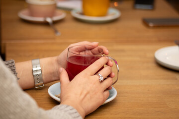 Hot tea in a mug and a girl's hands. Drinking a drink in a cafe