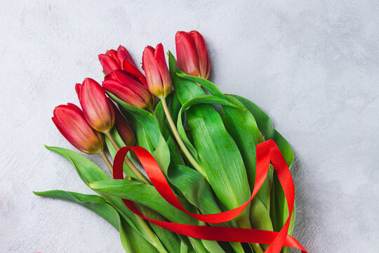 A bouquet of tulips tied with a red ribbon in the form of the number eight