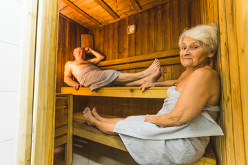 full shot of a senior Caucasian couple relaxing in the sauna on vacation. High quality photo