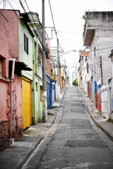 Houses, barrio and street in city with architecture, color and slum with buildings on urban road. Neighborhood, favela and apartment with expansion, home and ghetto housing project in Sao Paulo