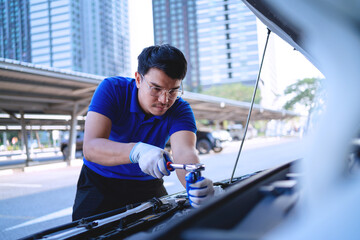  automobile car concept. Asian auto mechanic in blue uniform works on car engine Repair and...