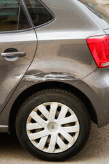 Broken Scratched Rear Fender Car. Scratched With Deep Damage To Paint. Close Up car with a damaged fender is parked on the side of the road, with broken automotive tail light. - 752329401