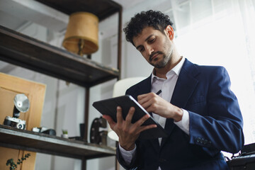 Successful businessman holding pointing typing digital tablet working at office. charming man Business man style.