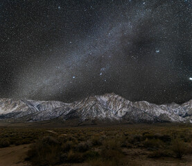 Milky Way creates a starry night sky over snow covered Mt Whitney and Sierra Nevada mountains