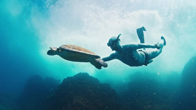 Freediver swims underwater with the turtle