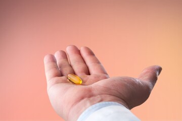 Human hand holding pill with fingers
