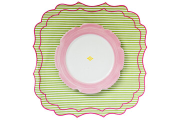 overhead shot of pretty pink plate with scalloped edge on green and pink linen placemat, easter...