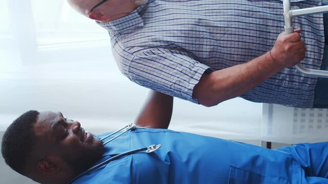 African-American caregiver and old man. Professional nurse and patient in a nursing home. Assistance, rehabilitation and health care concept.