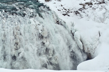 Majestic frozen waterfall with icicles and snow Location: Gullfoss Falls, Iceland.