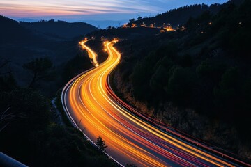 Photo of a winding highway at night with lights traces.