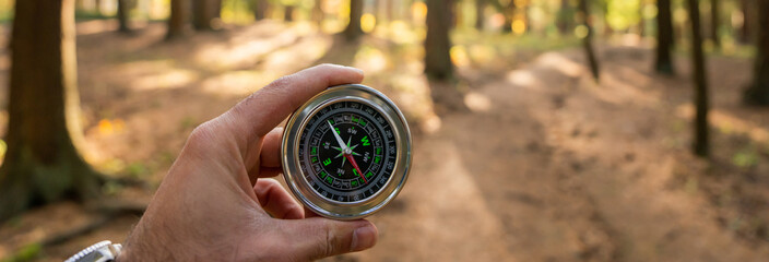 Holding a compass against the background of the forest © Daniel